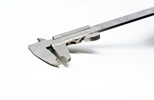 Detail view of a metallic caliper used to measure the distance between two opposite sides of an object. Engineering and construction industry. Isolated on a whote background