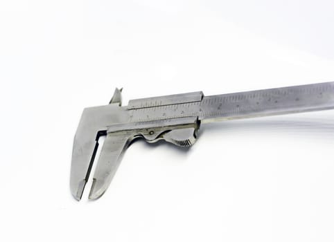 Detail view of a metallic caliper used to measure the distance between two opposite sides of an object. Engineering and construction industry. Isolated on a white background