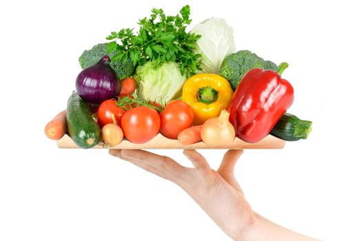 Concept of healthy food serving service - female hand holding a wooden board with various vegetables on a white background in close-up (composite image)
