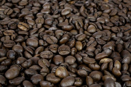 Premium coffee background - many roasted brown beans in close-up as a texture (high details).