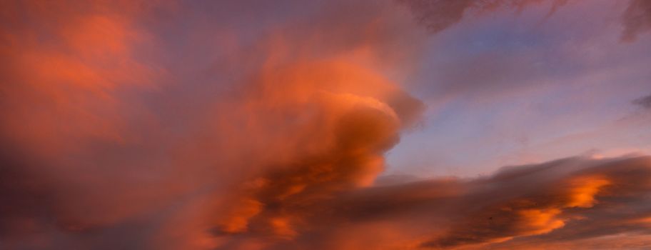 Bloody orange clouds in the evening sky as a natural background