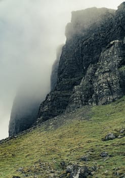 Mountains in Scotland with fog and grass in a cloudy day