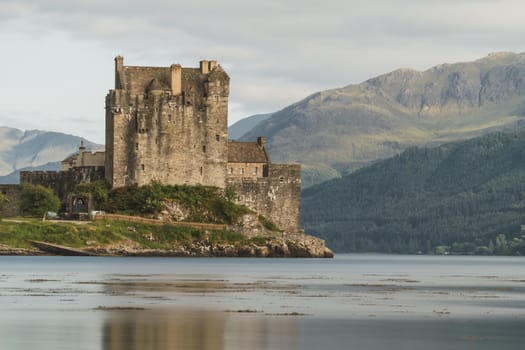 Old castle with a bridge with arcs and a river in a sunny day in Scotland, Eilean Donan Castle