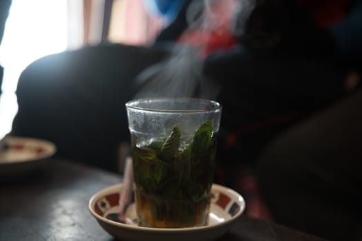 Hot bereber tea with smoke over a plate