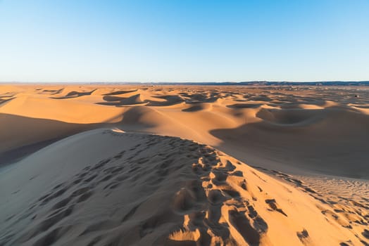 Sahara desert with footprints in the sand in Chegaga dune