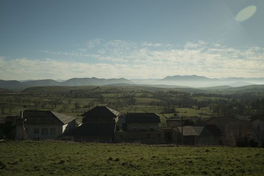 Beautiful landscape of grasslands fields with cable posts and mountains in sunny day