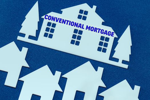 toy houses on a blue background. Text Conventional mortgage. The concept of profitable investment in real estate.