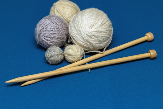 Balls of wool yarn for knitting on a blue background. Copy space for your design.