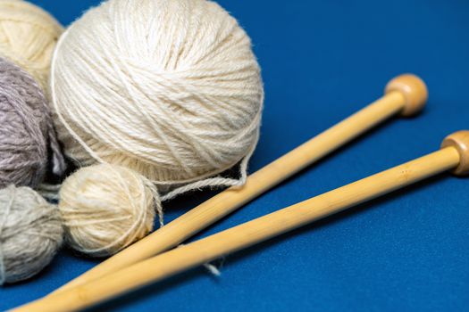 Balls of wool yarn for knitting on a blue background. Copy space for your design.