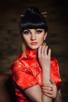 girl in a red Japanese silk dress qipao in a dark atmospheric room