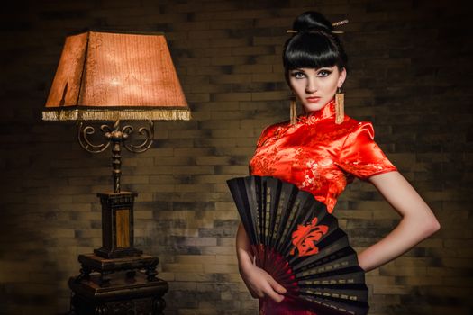 girl in a red Japanese silk dress qipao in a dark atmospheric room