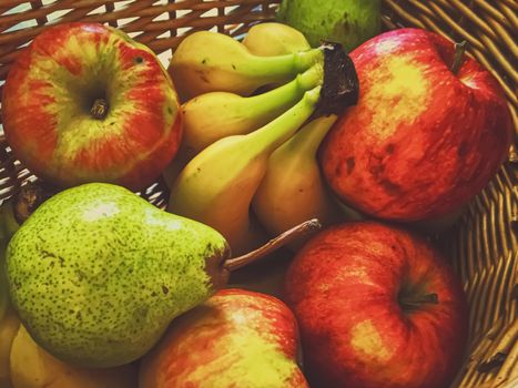 Organic apples, pears and bananas on rustic in a wicker basket, fruits farming and agriculture