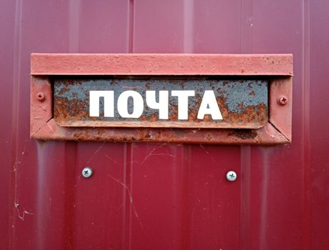 The inscription is mail. On a mailbox mounted in a fence.