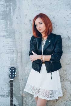 musician young girl with red hair with an acoustic guitar