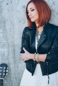 musician young girl with red hair with an acoustic guitar