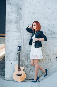 musician young girl with red hair with an acoustic guitar