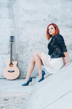 musician young girl with red hair with an acoustic guitar