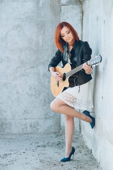 musician young girl with red hair with an acoustic guitar