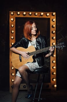 musician young girl with red hair with an acoustic guitar