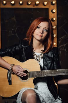 musician young girl with red hair with an acoustic guitar