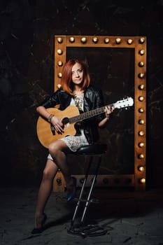 musician young girl with red hair with an acoustic guitar