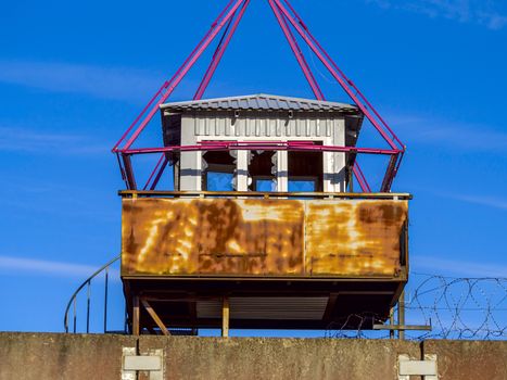 Old observation tower in abandoned Soviet Russian prison complex. Prison guarding tower, fence with barbed wire. Copy space