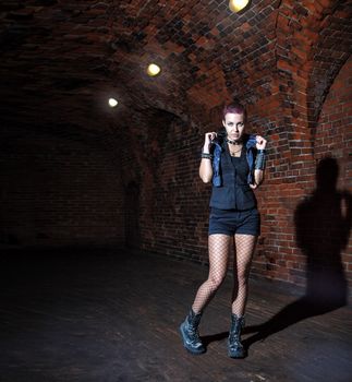 punk girl standing in the dark corridor of hte abandoned castle