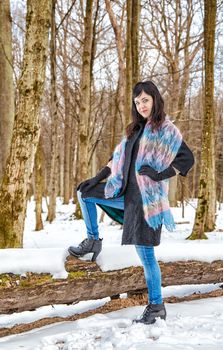 young beautiful woman walking in the woods in winter on sunny day