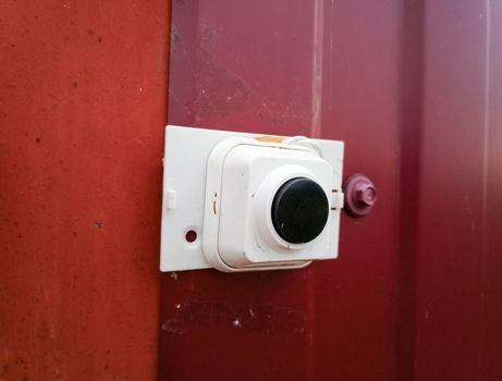 The call button on the fence near the gate.