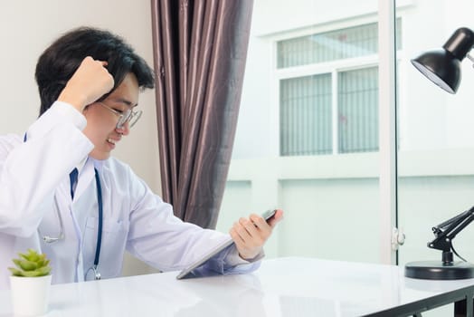 Happy Asian young doctor handsome man smile wear glasses use modern smart digital tablet computer explain patients symptoms of illness on desk at hospital office, Technology Healthcare And Medicine