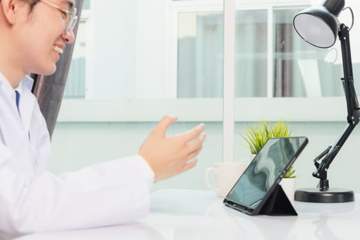 Happy Asian young doctor handsome man smile wear glasses use modern smart digital tablet computer explain patients symptoms of illness on desk at hospital office, Technology Healthcare And Medicine