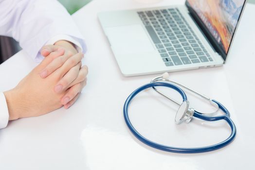 Medicine doctor's working on desk. Closeup of Stethoscope. Physician man video call sit hand in hand and listen patient explain on front laptop computer at hospital office, Healthcare medic concept