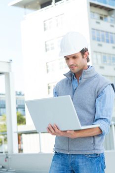 Confident male architect using laptop outdoors