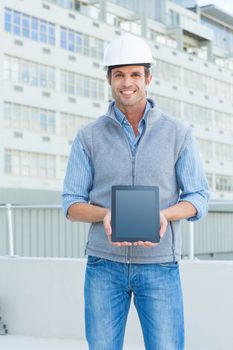 Portrait of happy male architect showing digital tablet outdoors