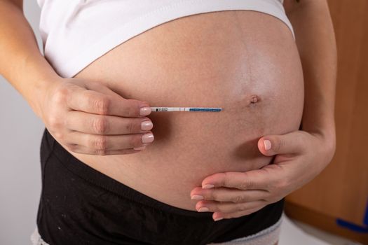 positive pregnancy test in woman hands close up.
