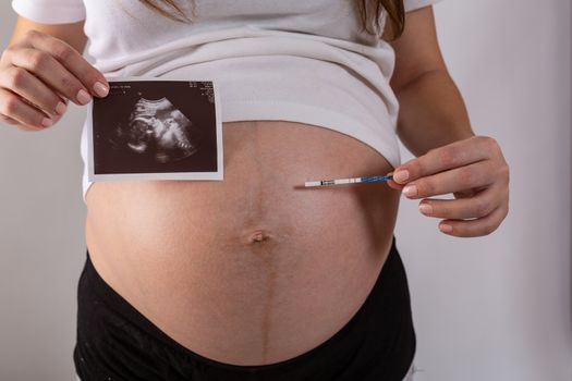 positive pregnancy test in woman hands close up.