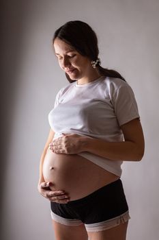 Pregnant woman touching belly close-up