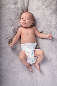 pretty smiling baby girl and toy rabbit lying in light background.