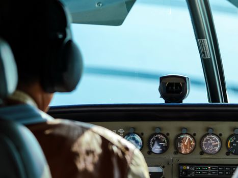 Rear view of pilot operating controls of private flight.