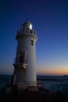 A beautiful night sky behind a White Lighthouse.