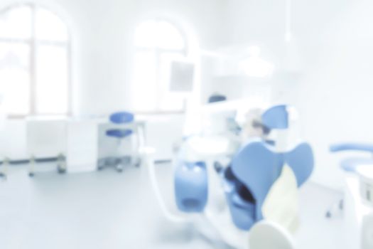 Blurred background of a dentist office with a patient on a chair ( copy space)