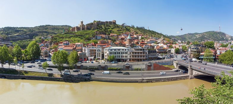 Panorama view of Tbilisi, capital of Georgia country. Landmarks - Narikala fortress, cable road above tiled roofs, Meidan square.