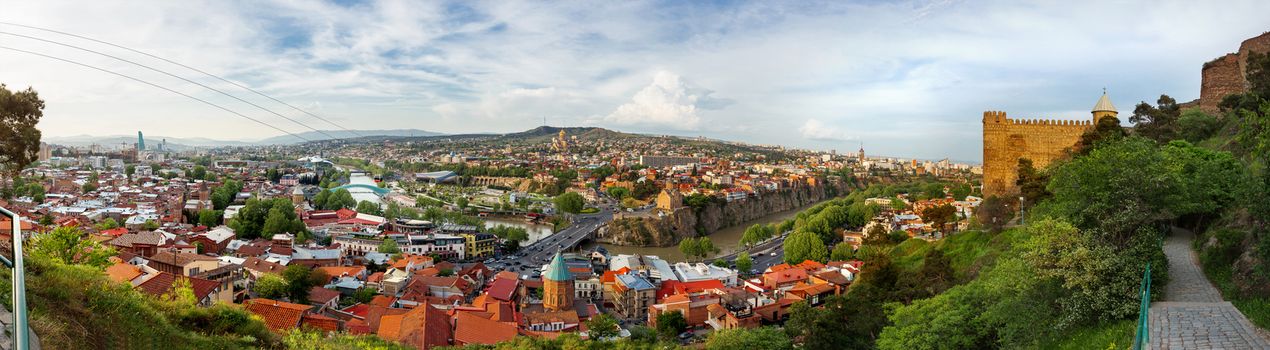Large panorama view of Tbilisi, capital of Georgia country. View from Narikala fortress. Cable road above tiled roofs.