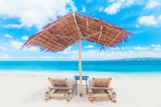 Beach chairs and umbrella made of straw and bamboo at beautiful tropical sea beach