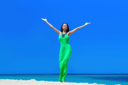 Happy smiling woman enjoy vacation on beach with raised hands