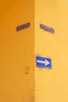 Matanzas, Cuba, one of the street signs. Bright yellow walls with street names and house numbers on it.