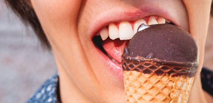 Man in blue shirt is eating ice-cream. Closeup photo of cold dessert. Summer fun.