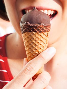 Woman in red shirt is eating ice-cream. Close up photo of cold dessert. Summer fun.