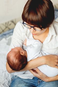 Woman holding a crying child. Mother comforts her little son or daughter.