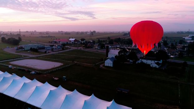 Aerial View of Sunrise with Hot air Balloons Taking Off with Glow as Seen by a Drone